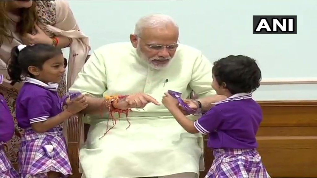 Children tie Rakhi to PM Narendra Modi on the occasion of Raksha Bandhan