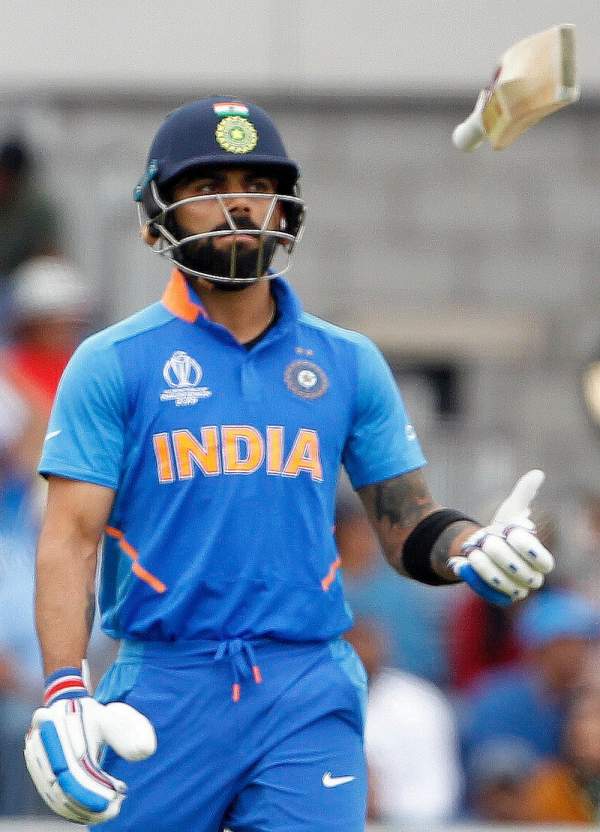 Indian captain virat kohli leaves the ground after being dismissed during the semi final match against new zealand