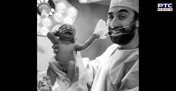 Photo of the year: Newborn baby pulls doctor’s mask